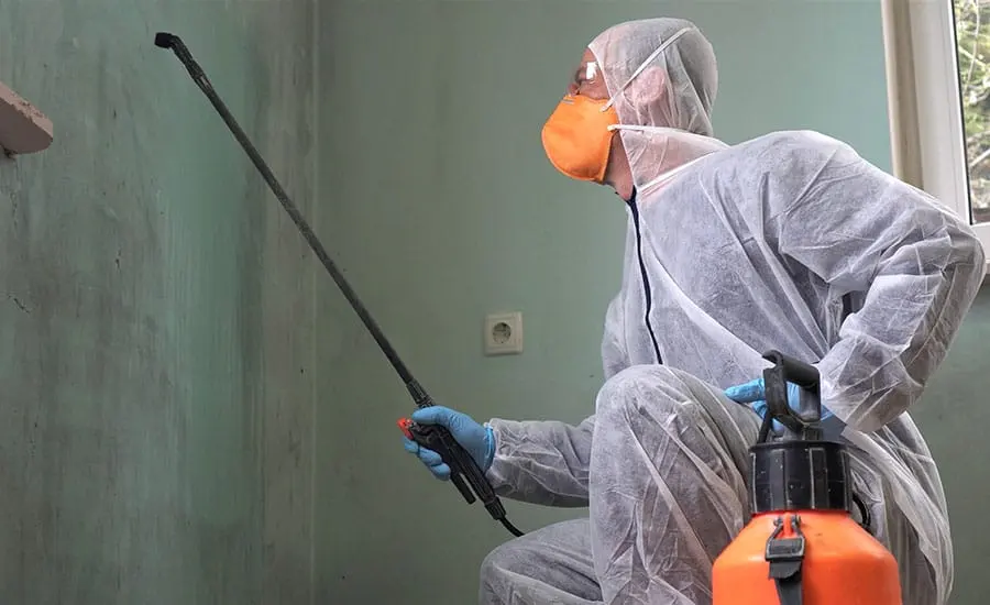 A technician in protective gear cleaning a sewage backup in Riverton, NJ
